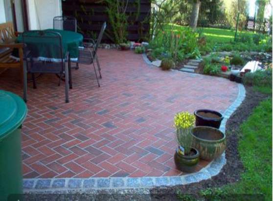 Klinkerpflaster mit Granit-Einfassung – Terrasse mit weichen Übergängen ins Beet.