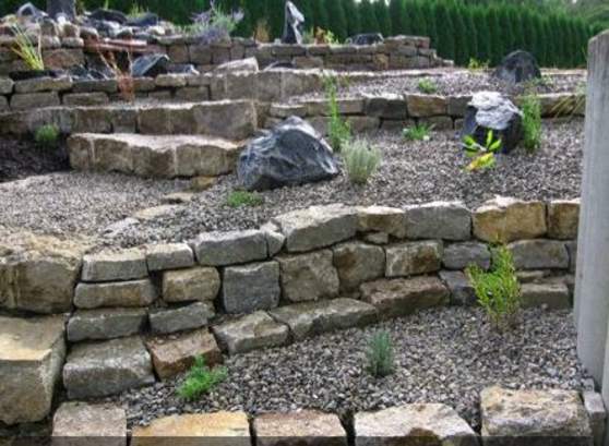 Trockenmauern und Sitzebenen verwandeln Hanglagen in nutzbaren Gartenraum.